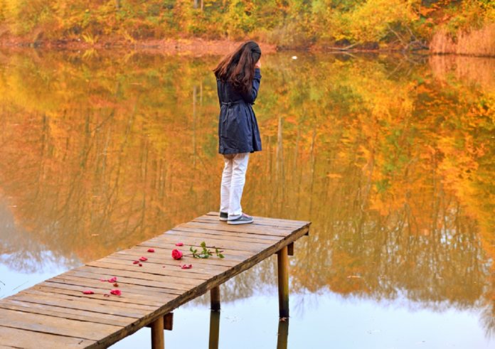 unhappy young girl in front of the fall landscape