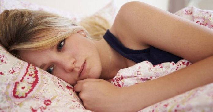 Worried Teenage Girl Lying In Bed