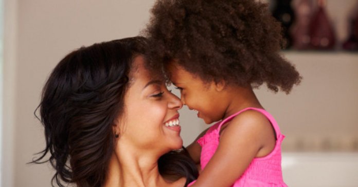 Mother Cuddling Daughter At Home