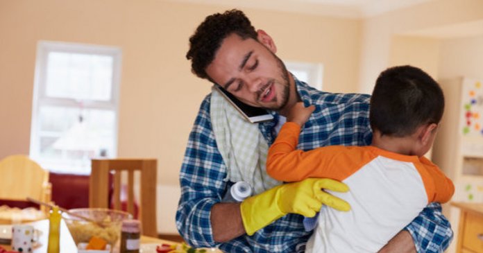 Busy Father Looking After Son Whilst Doing Household Chores