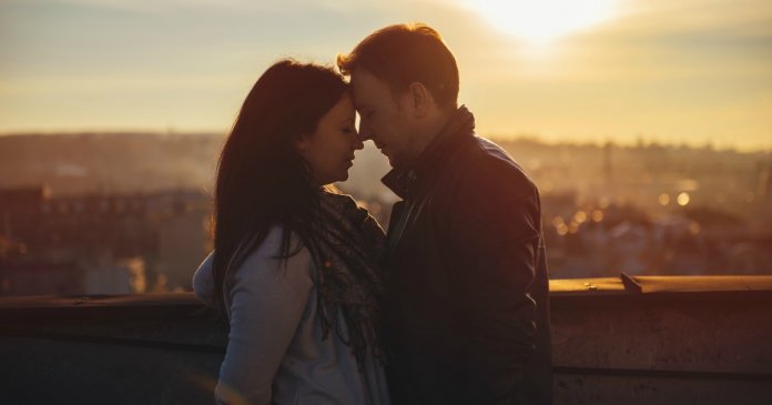 Affectionate Couple Looking at Each Other on the rooftop at the sunset